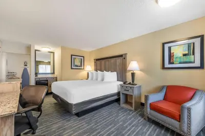 a hotel room with a bed and a chair at Best Western Americana Inn in San Ysidro, San Diego