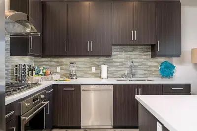 a kitchen with brown cabinets and a white counter top at Ocean View 3 Bedrooms Condo, just steps from the park, pier & water! in Imperial Beach