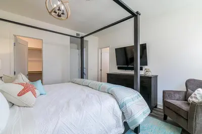 a bedroom with a large bed and a tv at Ocean View 3 Bedrooms Condo, just steps from the park, pier & water! in Imperial Beach