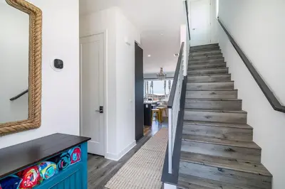 a staircase with a blue cabinet and a mirror at Ocean View 3 Bedrooms Condo, just steps from the park, pier & water! in Imperial Beach