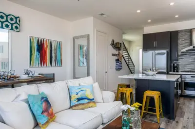 a living room with a white couch and a kitchen at Ocean View 3 Bedrooms Condo, just steps from the park, pier & water! in Imperial Beach