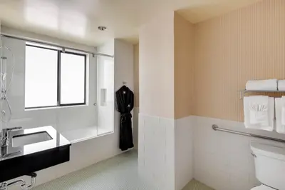 a bathroom with a sink and a toilet and a window at Cormorant Boutique Hotel in San Diego