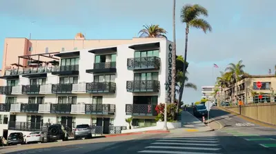 a large white building with balconies and a street at Cormorant Boutique Hotel in San Diego