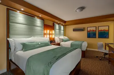 a hotel room with two beds and a desk at Cormorant Boutique Hotel in San Diego