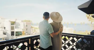 a man and a woman standing on a balcony at Cormorant Boutique Hotel in San Diego