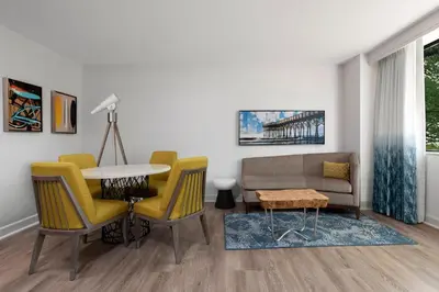 a living room with a couch and a table and chairs at Renaissance Newport Beach Hotel in Newport Beach