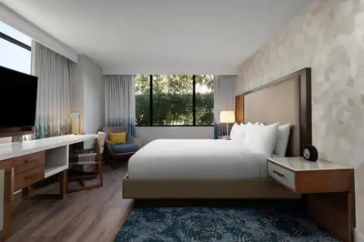 a bedroom with a bed and a desk and a tv at Renaissance Newport Beach Hotel in Newport Beach