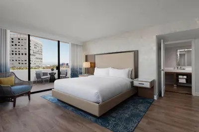 a bedroom with a large white bed and a large window at Renaissance Newport Beach Hotel in Newport Beach