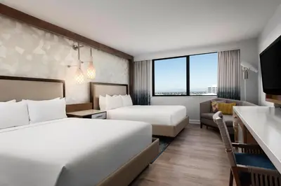 a hotel room with two beds and a couch at Renaissance Newport Beach Hotel in Newport Beach