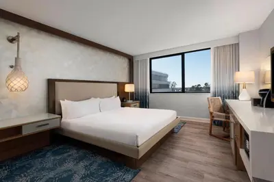 a hotel room with a large bed and a desk at Renaissance Newport Beach Hotel in Newport Beach