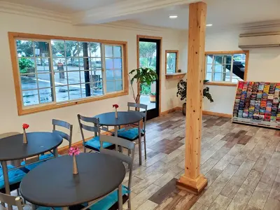 two tables and chairs in a room with windows at Studio 6-National City, CA - Naval Base San Diego in National City