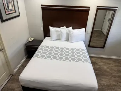 a hotel room with a large bed with a mirror at Rodeway Inn National City San Diego South in National City
