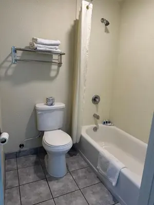 a bathroom with a white toilet and a bath tub at Rodeway Inn National City San Diego South in National City