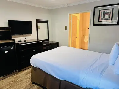 a bedroom with a bed and a flat screen tv at Rodeway Inn National City San Diego South in National City