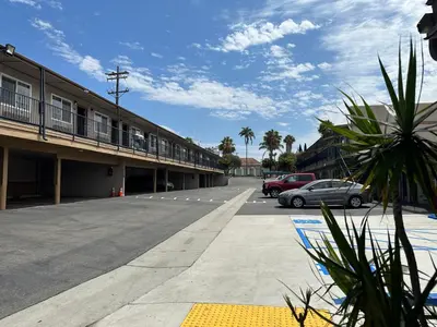 a parking lot with cars parked in front of a building at Rodeway Inn National City San Diego South in National City