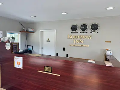 a hotel lobby with a reception counter and clocks on the wall at Rodeway Inn National City San Diego South in National City