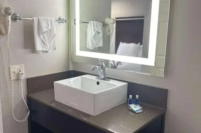 a bathroom with a white sink and a mirror at Rodeway Inn National City San Diego South in National City