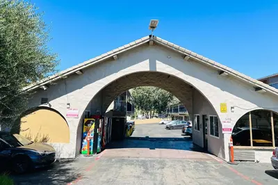 a large building with an arch over a parking lot at Rodeway Inn Lemon Grove San Diego East in Lemon Grove