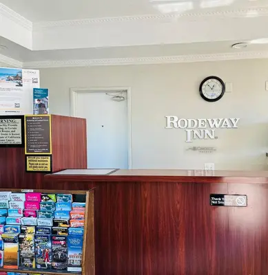 a reception desk with a clock on the wall at Rodeway Inn Lemon Grove San Diego East in Lemon Grove