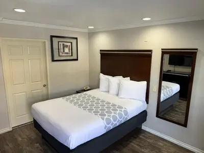 a hotel room with a bed and a mirror at Rodeway Inn Lemon Grove San Diego East in Lemon Grove