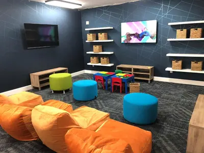 a childrens play room with an orange bed and chairs at Grand Pacific Palisades Resort in Carlsbad