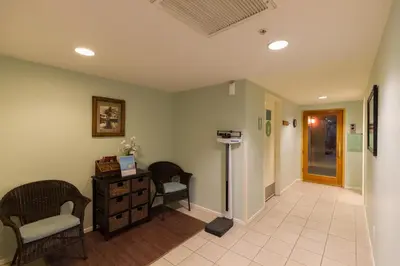 a hallway with a waiting room with two chairs and a desk at Grand Pacific Palisades Resort in Carlsbad