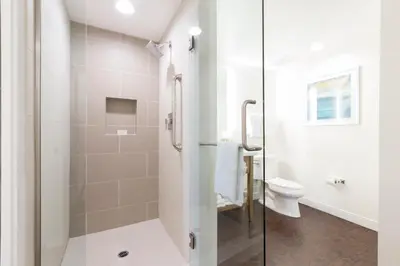 a white bathroom with a shower and a toilet at Grand Pacific Palisades Resort in Carlsbad