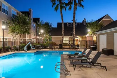 a swimming pool with lounge chairs and palm trees at Residence Inn San Diego Sorrento Mesa/Sorrento Valley in Sorrento