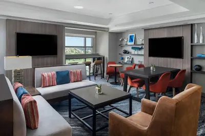 a living room with a couch and tables and chairs at San Diego Marriott Del Mar in San Diego