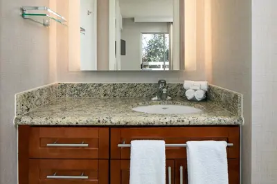a bathroom with a sink and a mirror and towels at Sonesta ES Suites Carmel Mountain - San Diego in San Diego