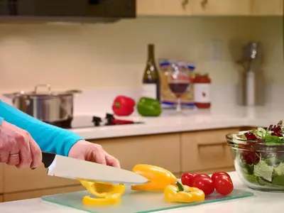 a person holding a knife in a kitchen at Sonesta ES Suites Carmel Mountain - San Diego in San Diego