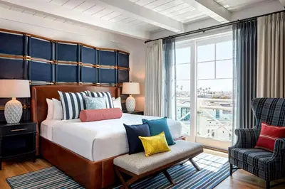 a bedroom with a large bed and a chair at Lido House, Autograph Collection in Newport Beach