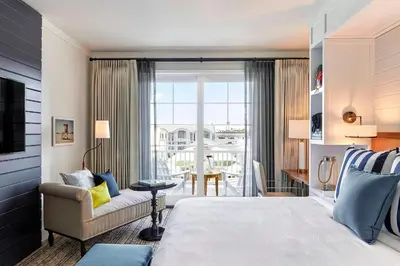 a bedroom with a bed and a couch and a window at Lido House, Autograph Collection in Newport Beach