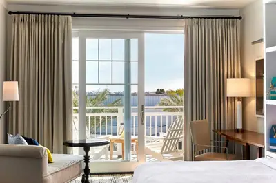 a hotel room with a bed and a view of a balcony at Lido House, Autograph Collection in Newport Beach