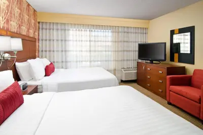 a hotel room with two beds and a television at Courtyard Irvine John Wayne Airport/Orange County in Irvine