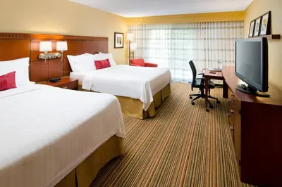 a hotel room with two beds and a desk and a television at Courtyard Irvine John Wayne Airport/Orange County in Irvine