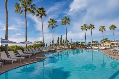 a swimming pool with chairs and palm trees at Marriott's Newport Coast Villas in Newport Beach