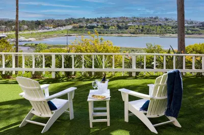 two white chairs and a table with a bottle of wine at Newport Beach Marriott Bayview in Newport Beach