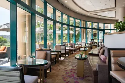 a restaurant with tables and chairs and windows at Newport Beach Marriott Bayview in Newport Beach