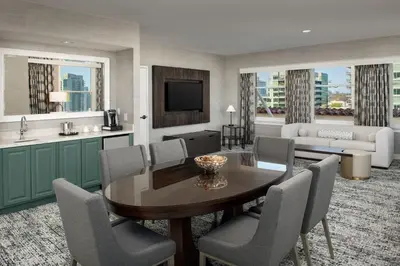 a living room with a table and chairs and a kitchen at Courtyard by Marriott San Diego Downtown in San Diego