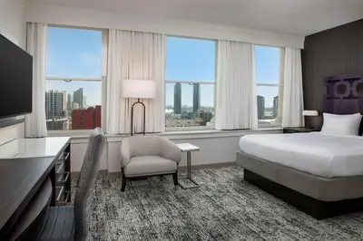 a hotel room with a bed and a chair and windows at Courtyard by Marriott San Diego Downtown in San Diego