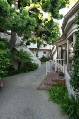 a walkway leading to a house with a white railing at Laguna Shores Studio Suites in Laguna Beach