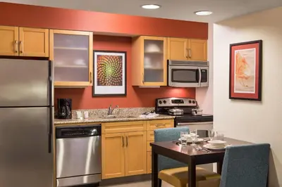 a kitchen with a stainless steel refrigerator and a table at Residence Inn San Diego La Jolla in San Diego