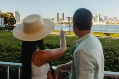 a man and woman sitting on a bench looking at the city at Coronado Island Marriott Resort & Spa in San Diego