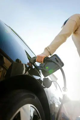 a person is holding a fuel nozzle on a car at Residence Inn Irvine Spectrum in Irvine