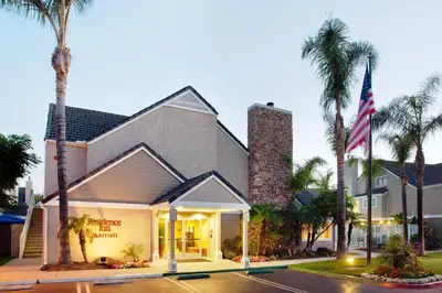 a building with an american flag and palm trees at Residence Inn Irvine Spectrum in Irvine