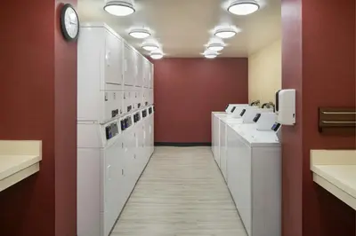 a bathroom with white sinks and red walls at Residence Inn Irvine John Wayne Airport Orange County in Irvine