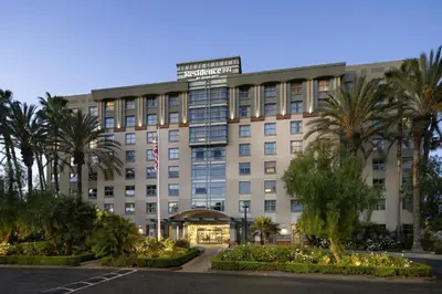 a hotel with palm trees in front of a building at Residence Inn Irvine John Wayne Airport Orange County in Irvine