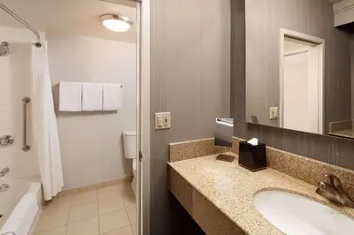 a bathroom with a sink and a toilet and a mirror at Sonesta Select Laguna Hills Irvine Spectrum in Laguna Hills