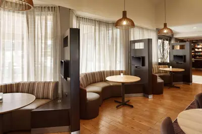a hotel room with couches and tables and chairs at Sonesta Select Laguna Hills Irvine Spectrum in Laguna Hills